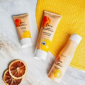 Citrus-themed skincare products arranged creatively on a textured surface with sliced oranges.